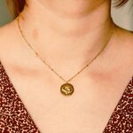 collier pendentif avec medaille motif poisson en relief representant le signe astrologique porte