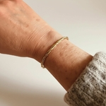 bracelet jonc torsadé anne doré et porté au poignet