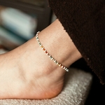bracelet de cheville perles multicolores acier inoxydable porte sur cheville fond marron