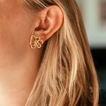 puces d oreilles fleur ajourée Maribelle en acier doré portées sur l oreille bijou délicat et lumineux