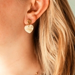 boucles d oreilles coeur beige Assia avec pendentif nacré portées sur oreille