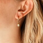 creoles goutte dorees alba avec cristal reflets champagne portees en gros plan sur oreille
