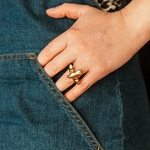 bague oiseau Luna dorée portée a la main avec jean bleu en arrière plan