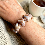 bracelet grosses perles étoiles lana porté au poignet avec reflets beige caramel