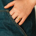 bague maillons Nelia portée a la main avec un jean en acier inoxydable doré