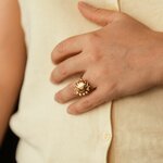 bague tournante Solis en acier inoxydable doré portée avec une tenue beige
