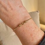 bracelet menotte Isée en acier doré porté au poignet avec chaine maille vénitienne