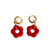boucles d oreilles creoles pendentif fleur en resine et accroche en acier dore exposees fond blanc elise