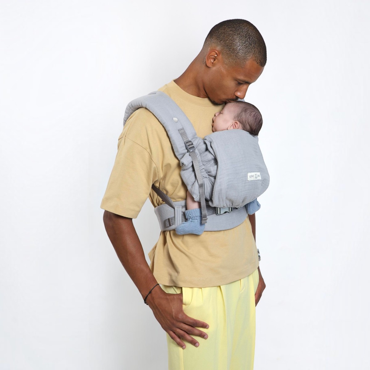 Papa portant un nouveau-né avec le PhysioCarrier 2 Grey Love Radius
