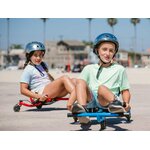Deux enfants casqués roulent sur des Ezyroller Spinner X, l’un en bleu et l’autre en rouge, en jouant sur une zone dégagée en plein air.