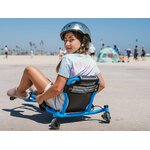 Une enfant casquée roule en Ezyroller Spinner X bleu sur une zone dégagée et se retourne vers l’appareil photo.