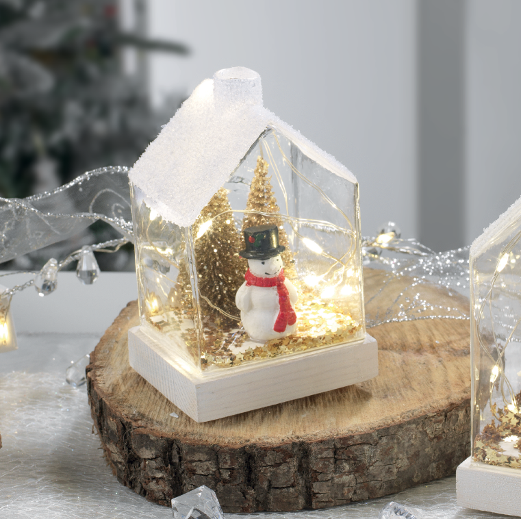 Petite maison lumineuse avec bonhomme de neige