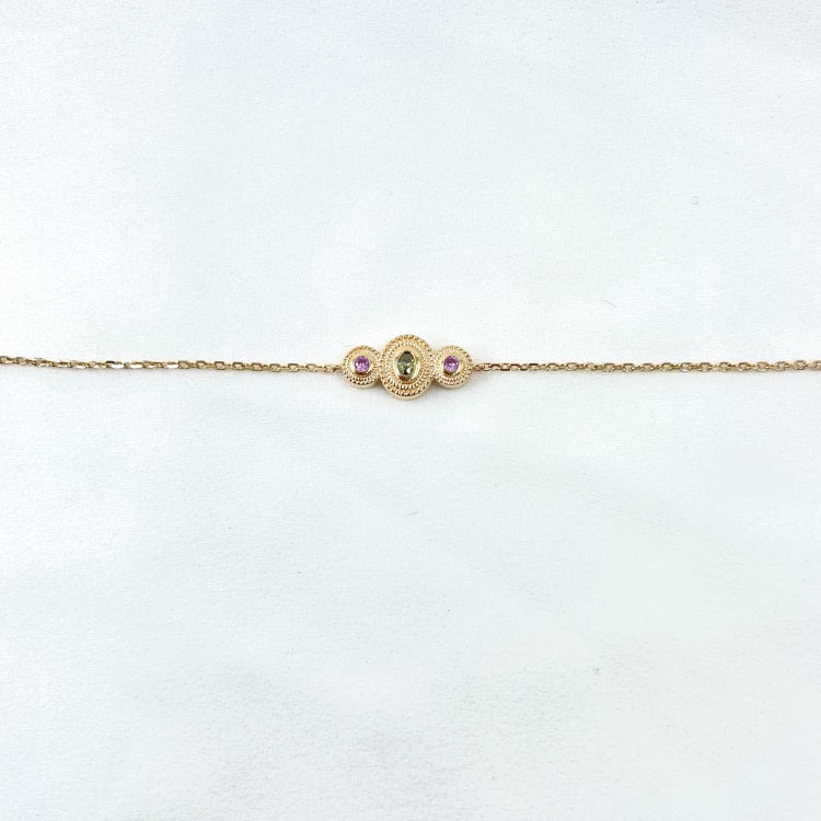 Bracelet Mahe : Bracelet orné de trois cercles perlés sertis de pierres de synthèse violette et verte. En plaqué or 3 microns