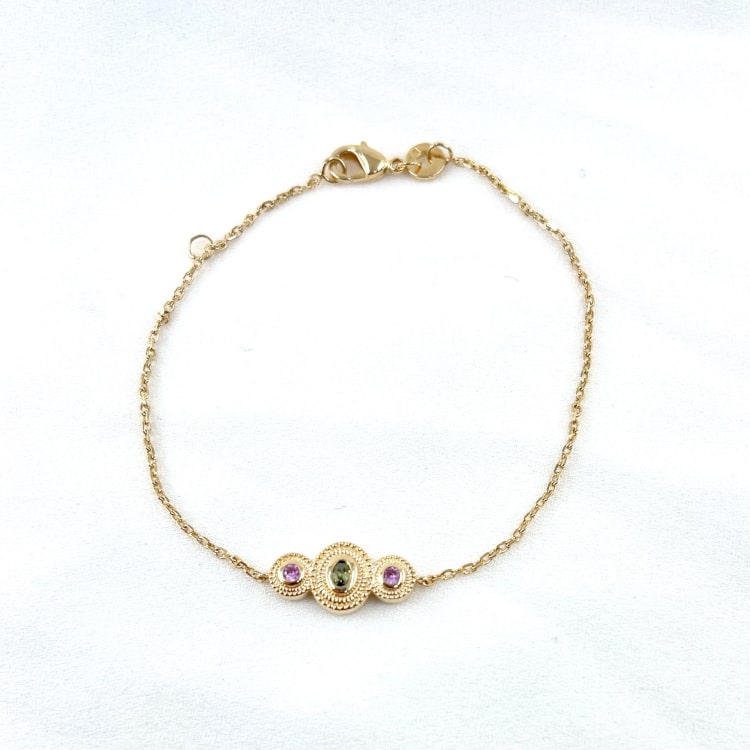 Bracelet Mahe: Bracelet orné de trois cercles perlés sertis de pierres de synthèse violette et verte. En plaqué or 3 microns