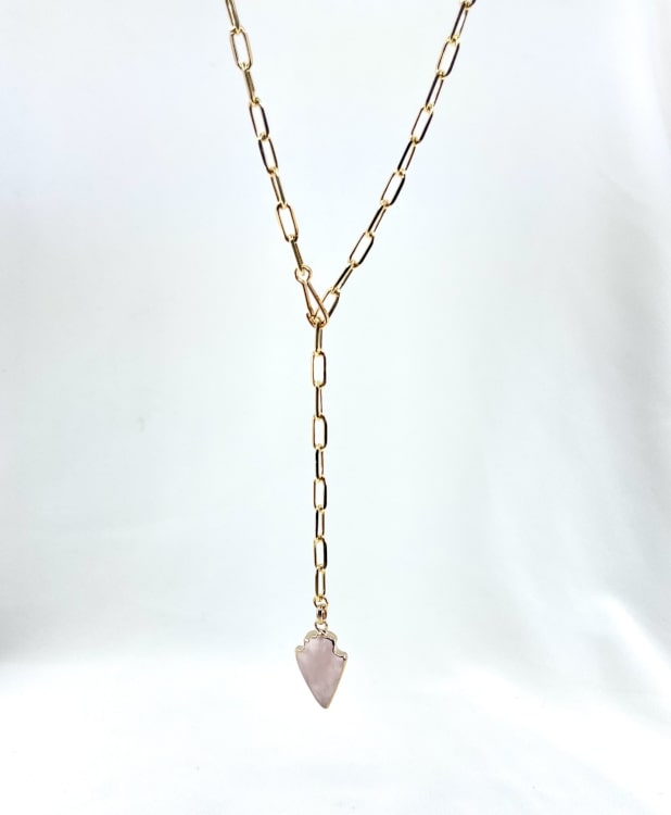 Arrow: Collier en maille rectangulaire accompagné dun joli pendentif flèche en quartz rose. En plaqué or 3 microns
