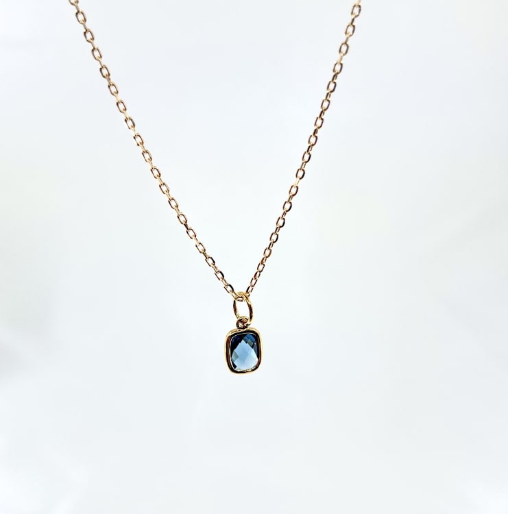 Collier Nelson : Collier composé dune chaine fine et dun pendentif rectangulaire serti dun oxyde de zirconium bleu. En plaqué or 3 microns