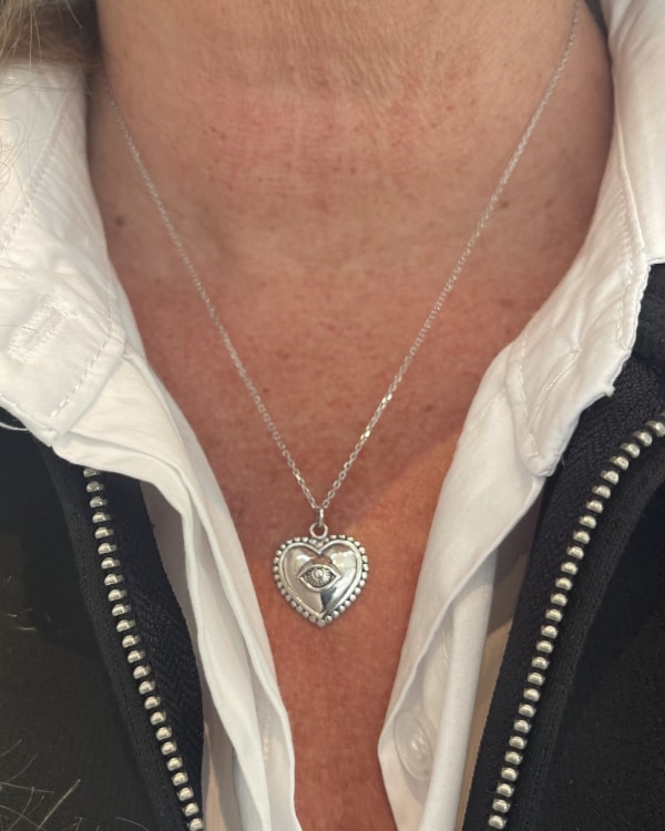 Nathan: collier composé dune chaine fine et dun pendentif coeur doté dun petit oeil en relief en son centre. En argent 925