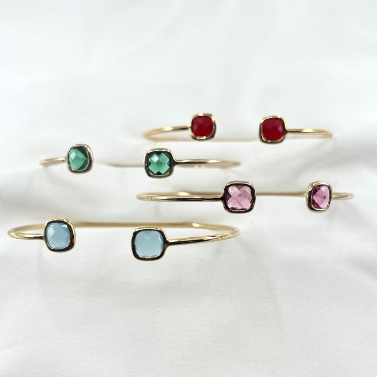 Jonc Edgar : jonc ouvert fin et délicat orné de deux oxydes de zirconium aux extrémités de couleur rouge, vert, bleu ciel ou rose pale. En plaqué or 3 microns