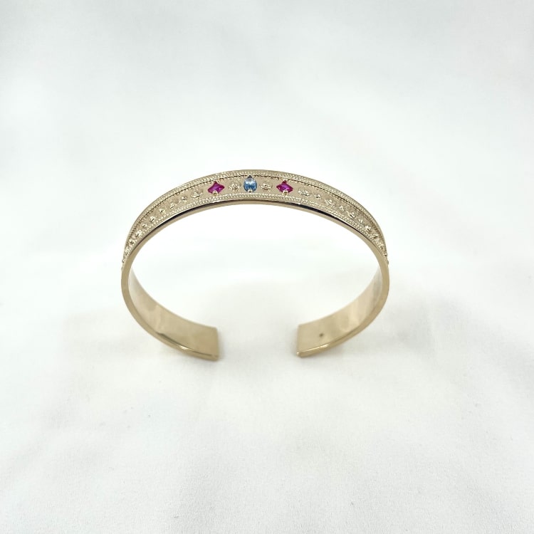 Jonc solal: jonc à lallure de bijou ancien délicatement travaillé et serti de zirconiums rose et bleu. En plaqué or 3 microns 18 carats