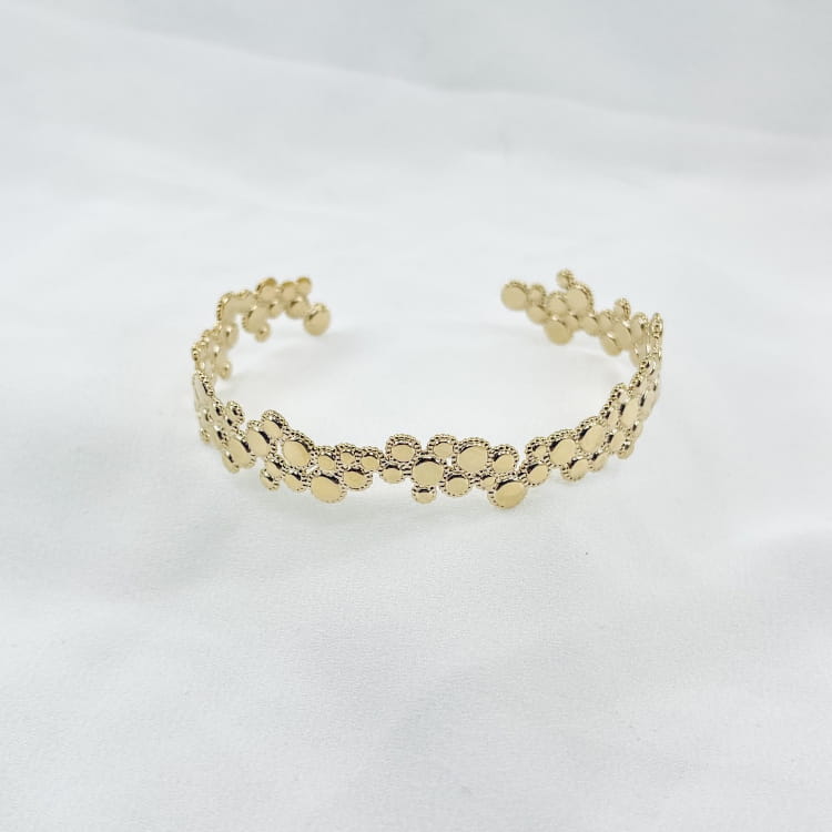 Jonc Sunny: bracelet rigide ouvert et irrégulier composé de petits ronds perlés de tailles différentes. En plaqué or 3 microns  18 carats