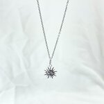 Collier louis : Collier composé dune chaine fine et dun pendentif en forme de soleil gravé dun petit visage en son centre. En argent 925