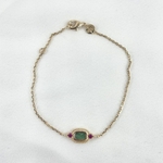 Imani: Bracelet composé d'une chaine fine sertie d'une pierre verte en jaspe dalmatien et de deux oxydes de zirconium fuchsia. En plaqué or