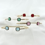 Jonc Edgar : jonc ouvert fin et délicat orné de deux oxydes de zirconium aux extrémités de couleur rouge, vert, bleu ciel ou rose pale. En plaqué or 3 microns