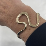 Jonc Marceau:  jonc ouvert lisse et lumineux au design original.  En plaqué or 3 microns 18 carats