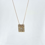 Collier Steeve: collier composé d'une chaine fine et d'un pendentif rectangulaire incrusté de zirconiums blancs formant un joli soleil. En plaqué or 3 microns 18 carats