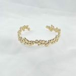 Jonc Sunny: bracelet rigide ouvert et irrégulier composé de petits ronds perlés de tailles différentes. En plaqué or 3 microns  18 carats