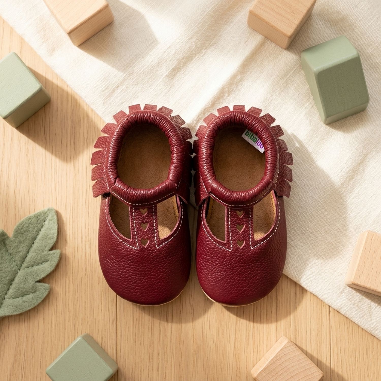 chaussons-bebe-cuir-souple-ouverts-bordeaux-mise-en-scene-jouets-6