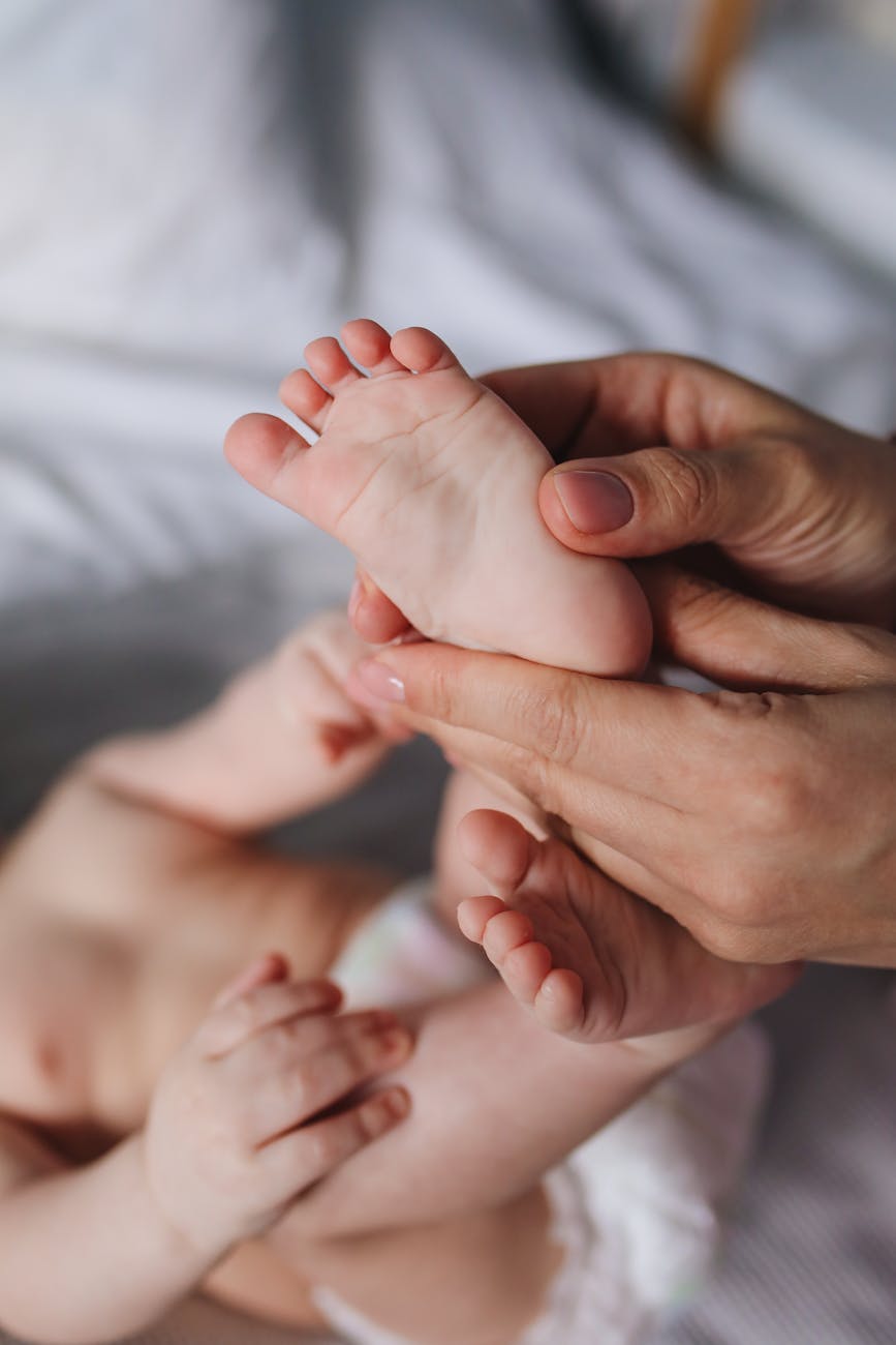 maman qui masse le pied d'un bébé
