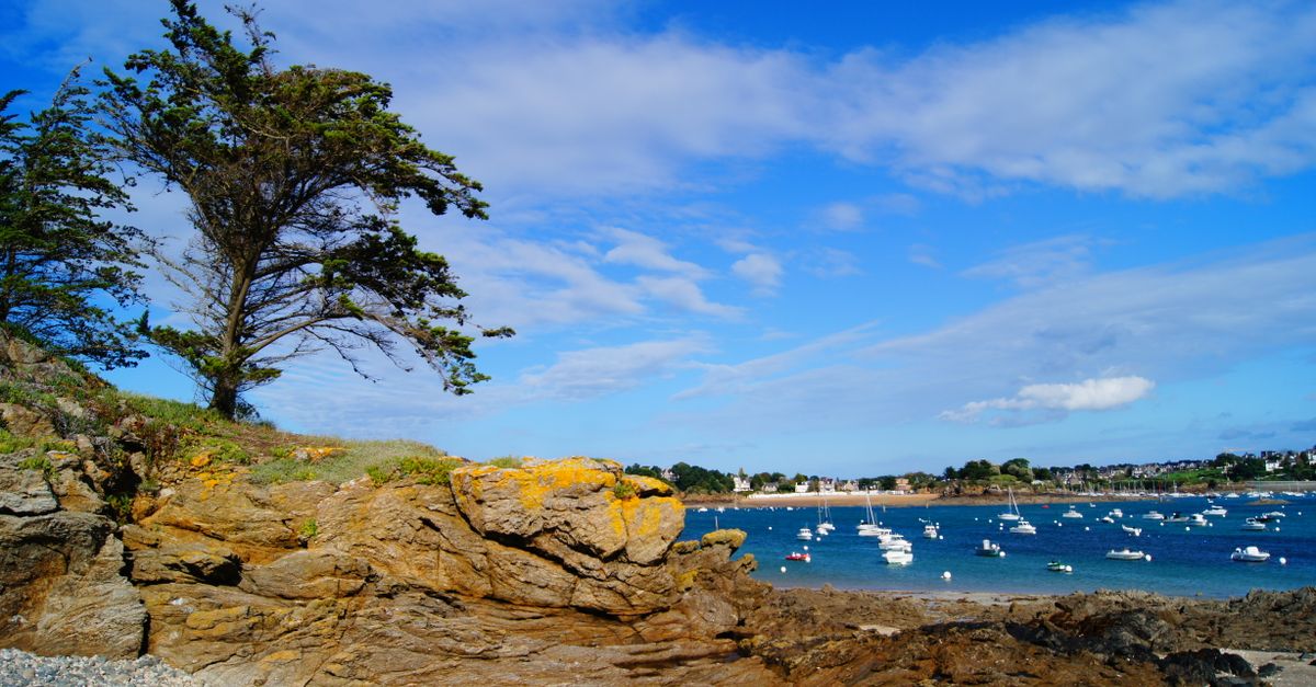paysage cotier pittoresque avec ciel bleu bateaux et terrain rocheux