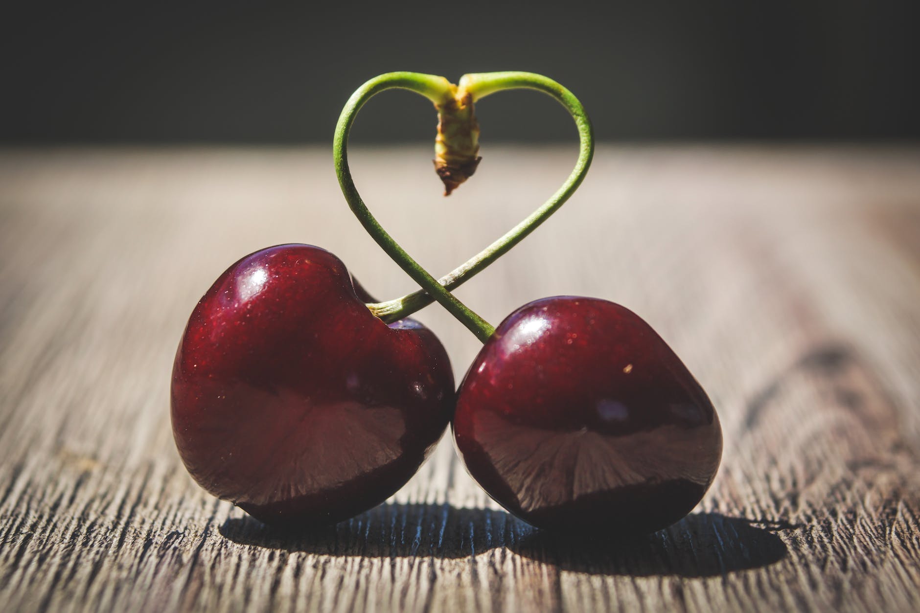 Deux Cerises Rouges Sur Surface Brune