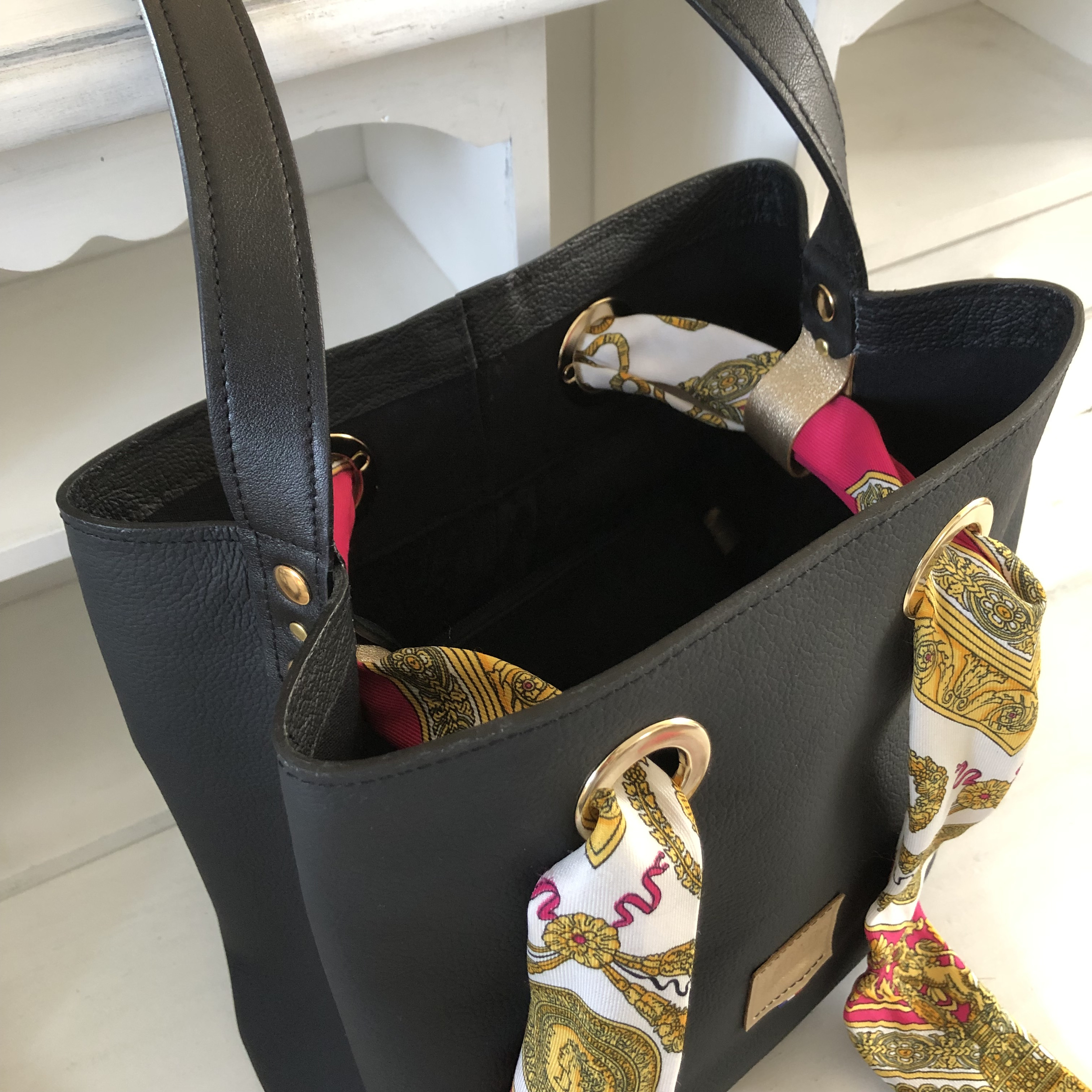 sac seau noir en cuir ouvert vue du dessus avec foulard lien dans œillets