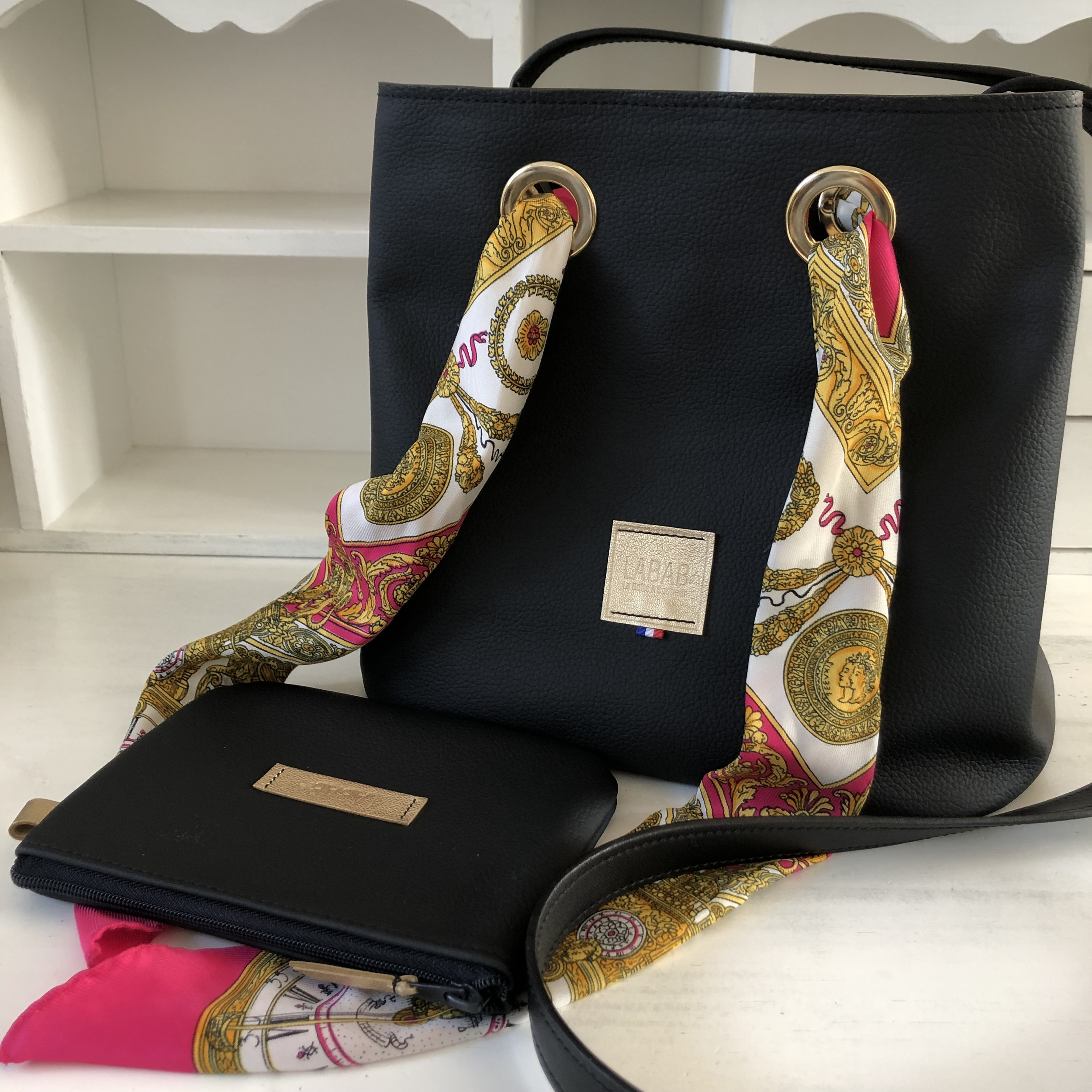 sac seau cuir noir sur mesure de face lien en foulard dénoué et pochette couchée devant