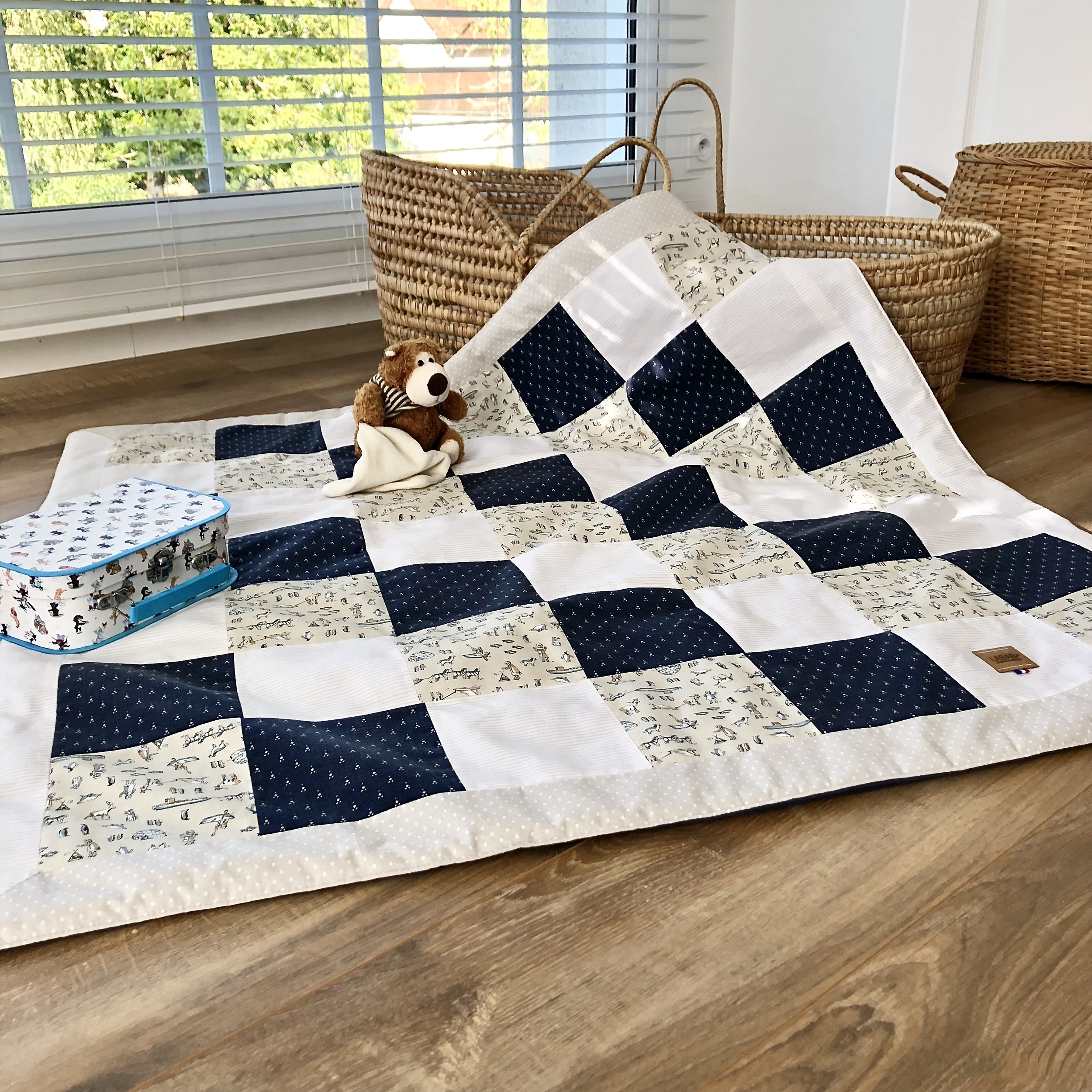 Patchwork beige et bleu présenté en tapis de jeux bébé