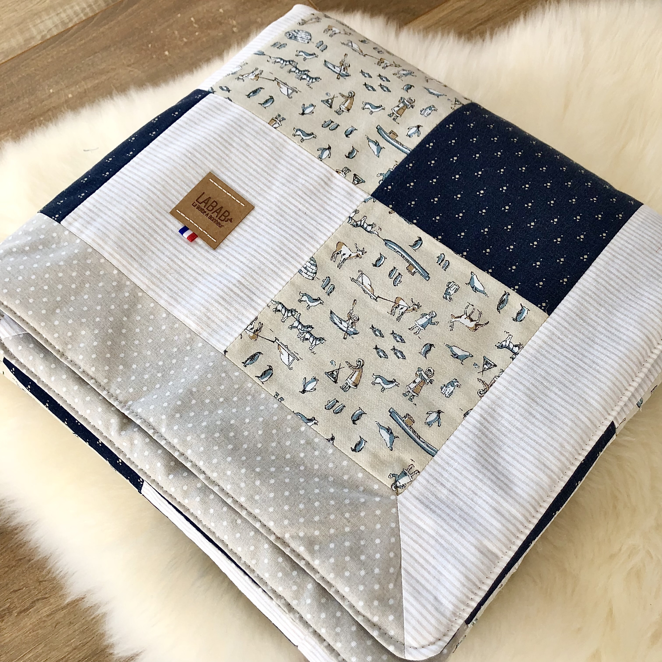 Détails des 4 tissus du patchwork: esquimaux et pingouins sur la banquise, rayé beige et blanc, pois blanc sur fond beige, petits motifs beige sur fond bleu