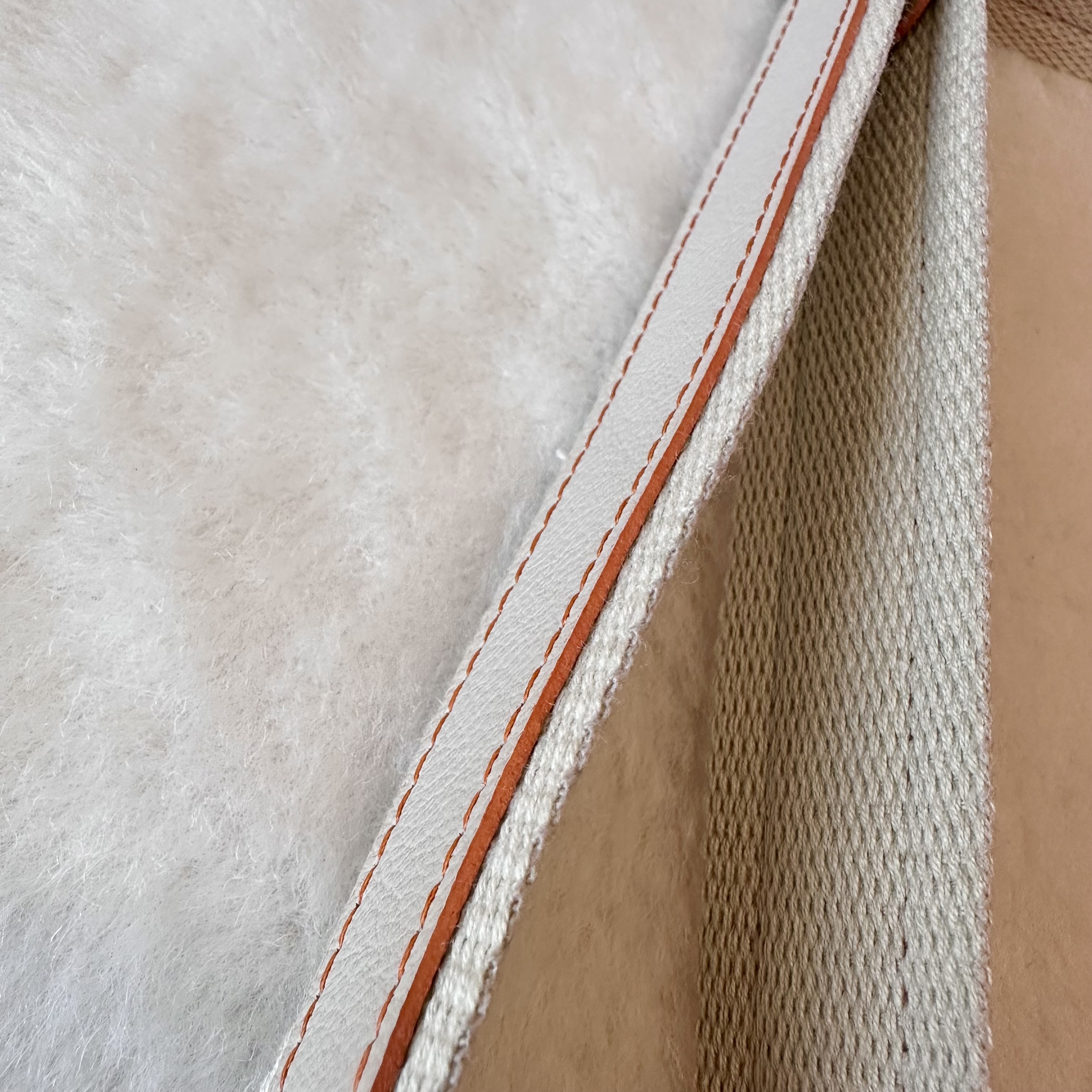 gros plan sur tranche cuir teintée sur mesure rouille de la bandoulière