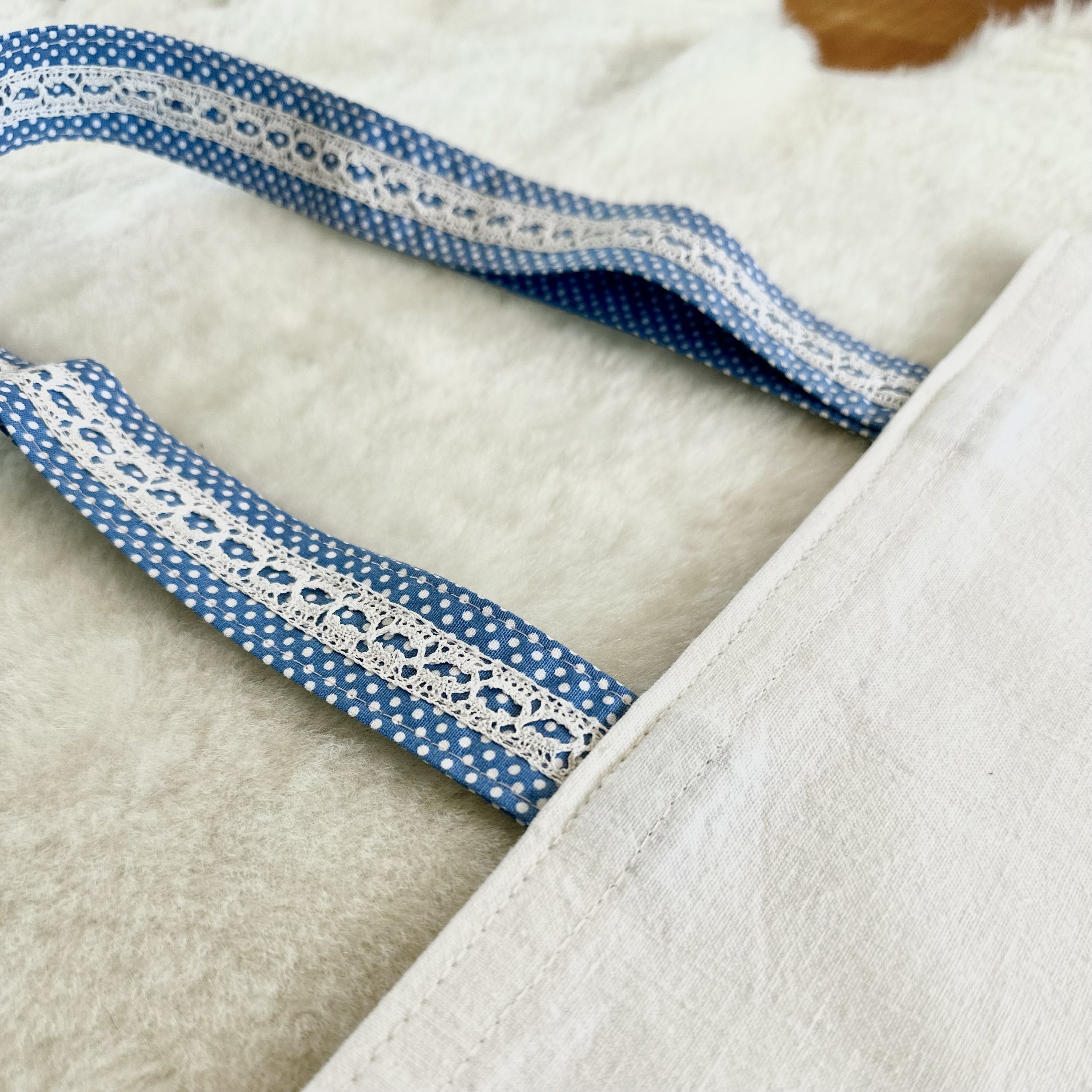 anses en tissu bleu à pois blanc avec dentelle anciennes cousue dessus
