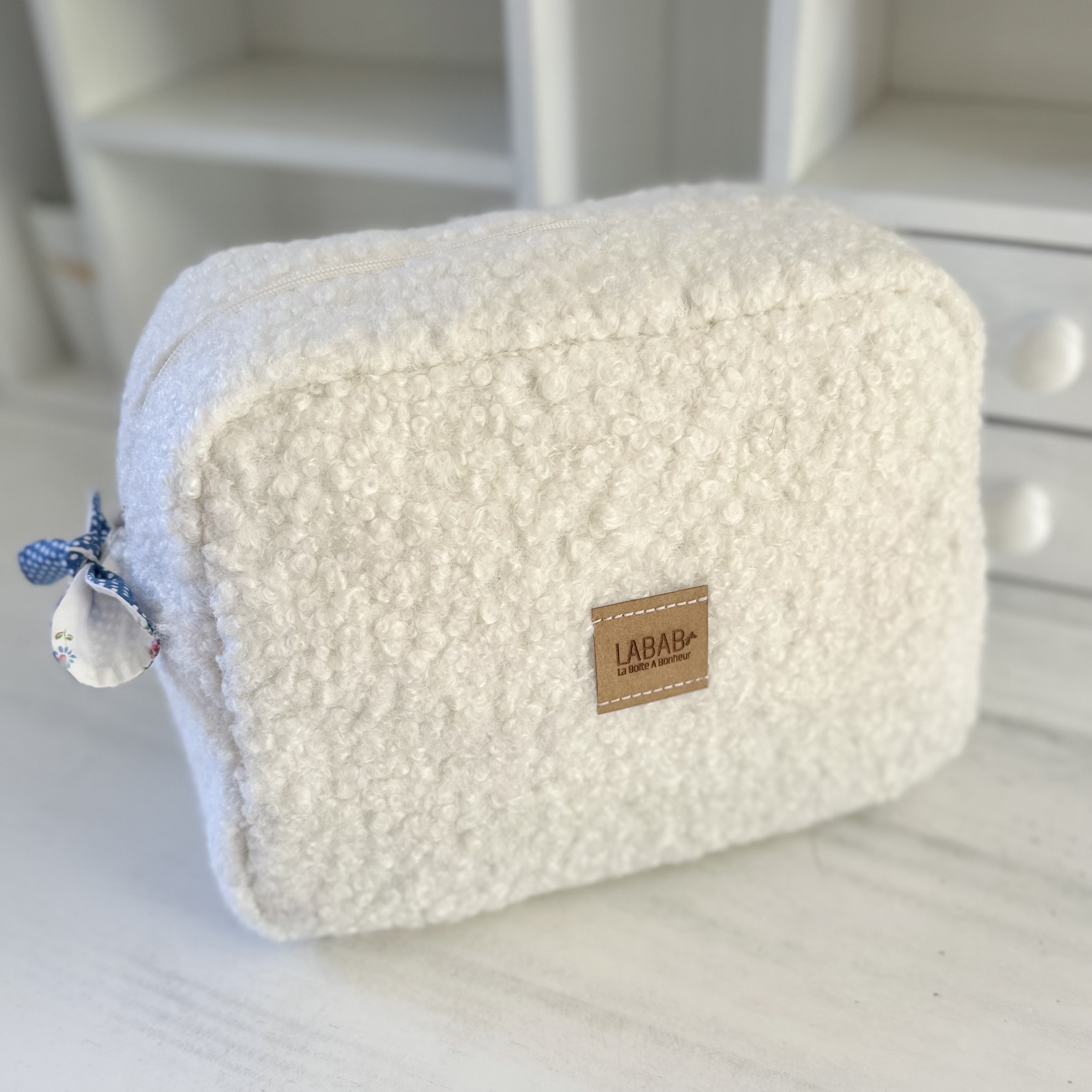 trousse sur mesure en teddy bouclé vue de face avec noeud tissu sur la tireete