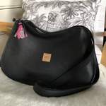 sac à main sur mesure en cuir noir de face avec bijoux de sac pompon en foulard rose