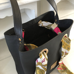sac seau noir en cuir ouvert vue du dessus avec foulard lien dans œillets