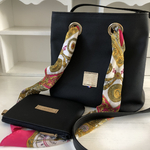 sac seau cuir noir sur mesure de face lien en foulard dénoué et pochette couchée devant