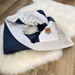 Vue des 2 faces: 1 patchwork  de 4 tissus en petits carrés et 1 face unie en double-gaze bleu marine, étiquette logo et ruban tricolore