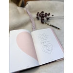 Carnet et protège-carnet ouverts: sur la page de droite une citation sur le bonheur et sur la gauche, un demi cœur rose