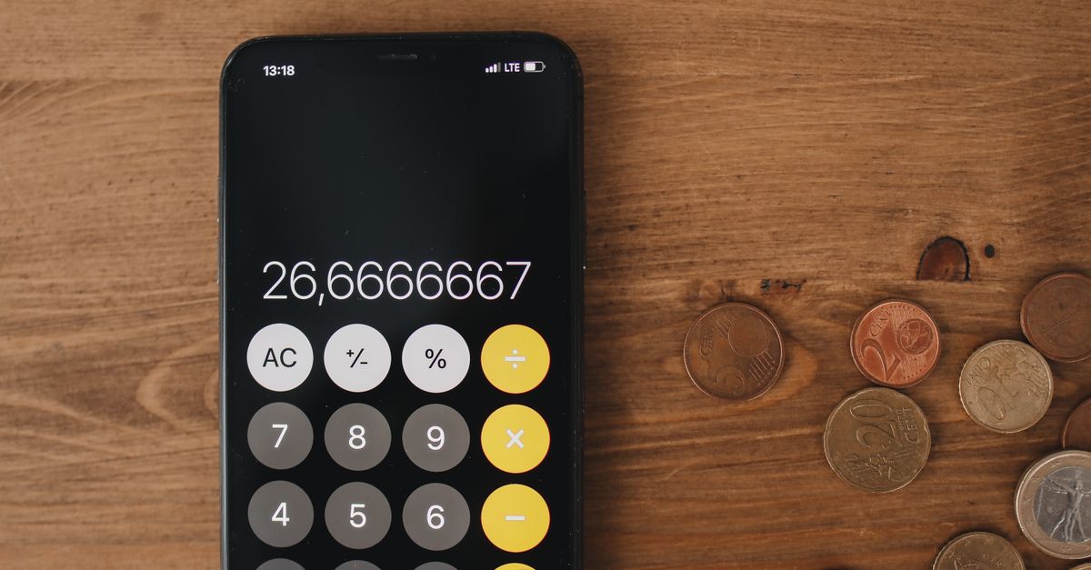 gros plan d une calculatrice de smartphone et de pieces de monnaie sur une surface en bois pour une metaphore financiere