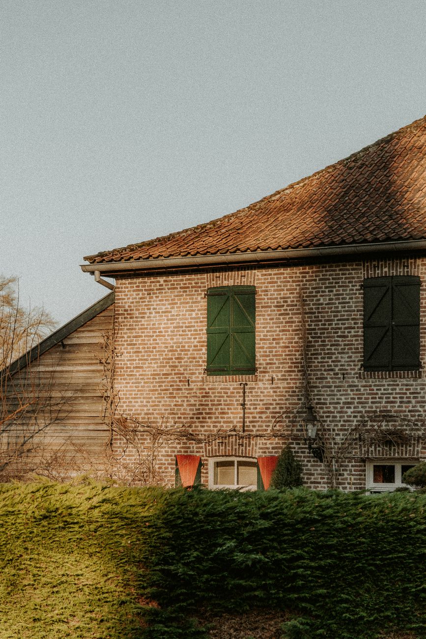 capture d une maison en brique vintage avec des volets verts dans un cadre rural calme