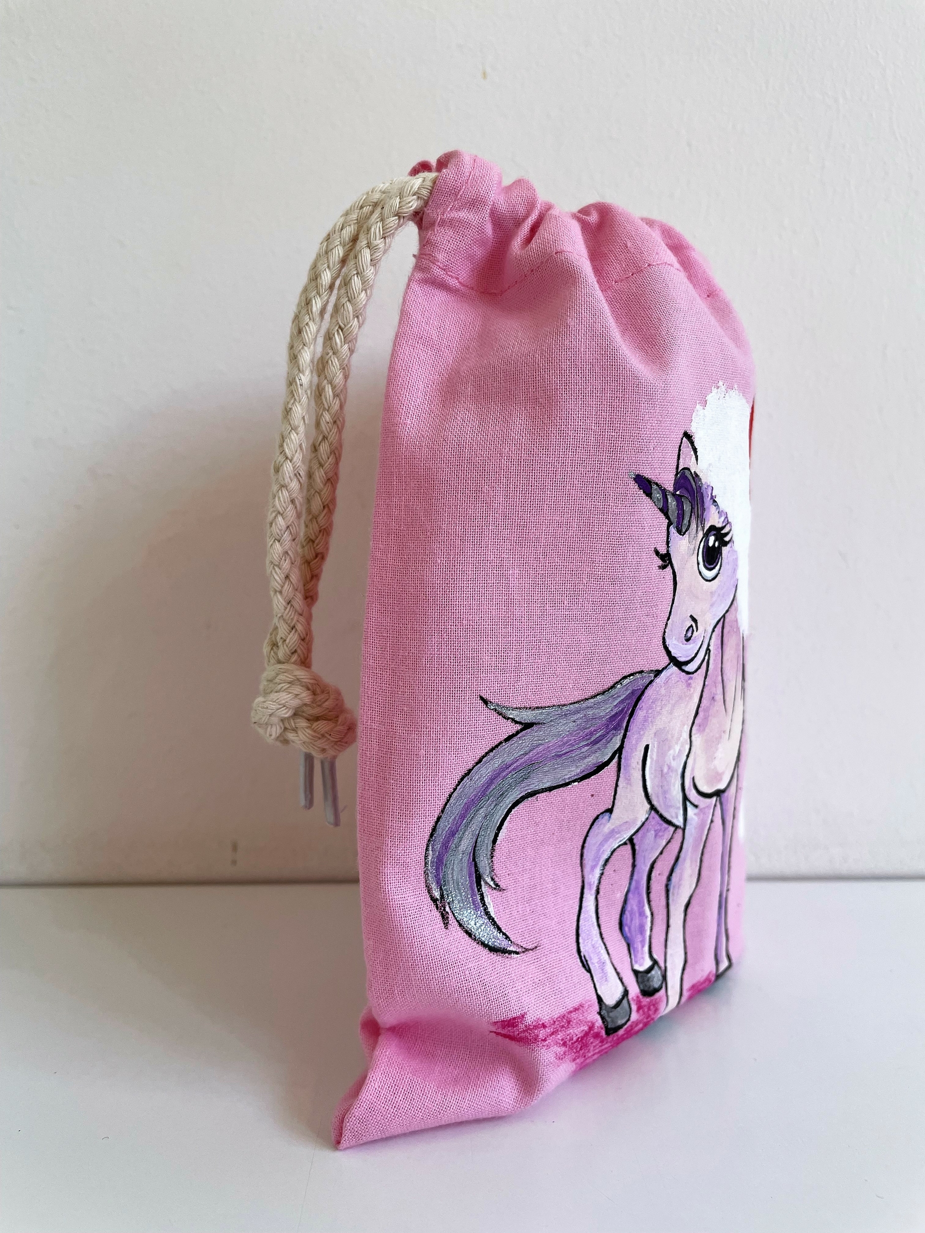 pochon rose en coton avec une licorne coiffée dun père Noël peinte à la main par Elles et No.