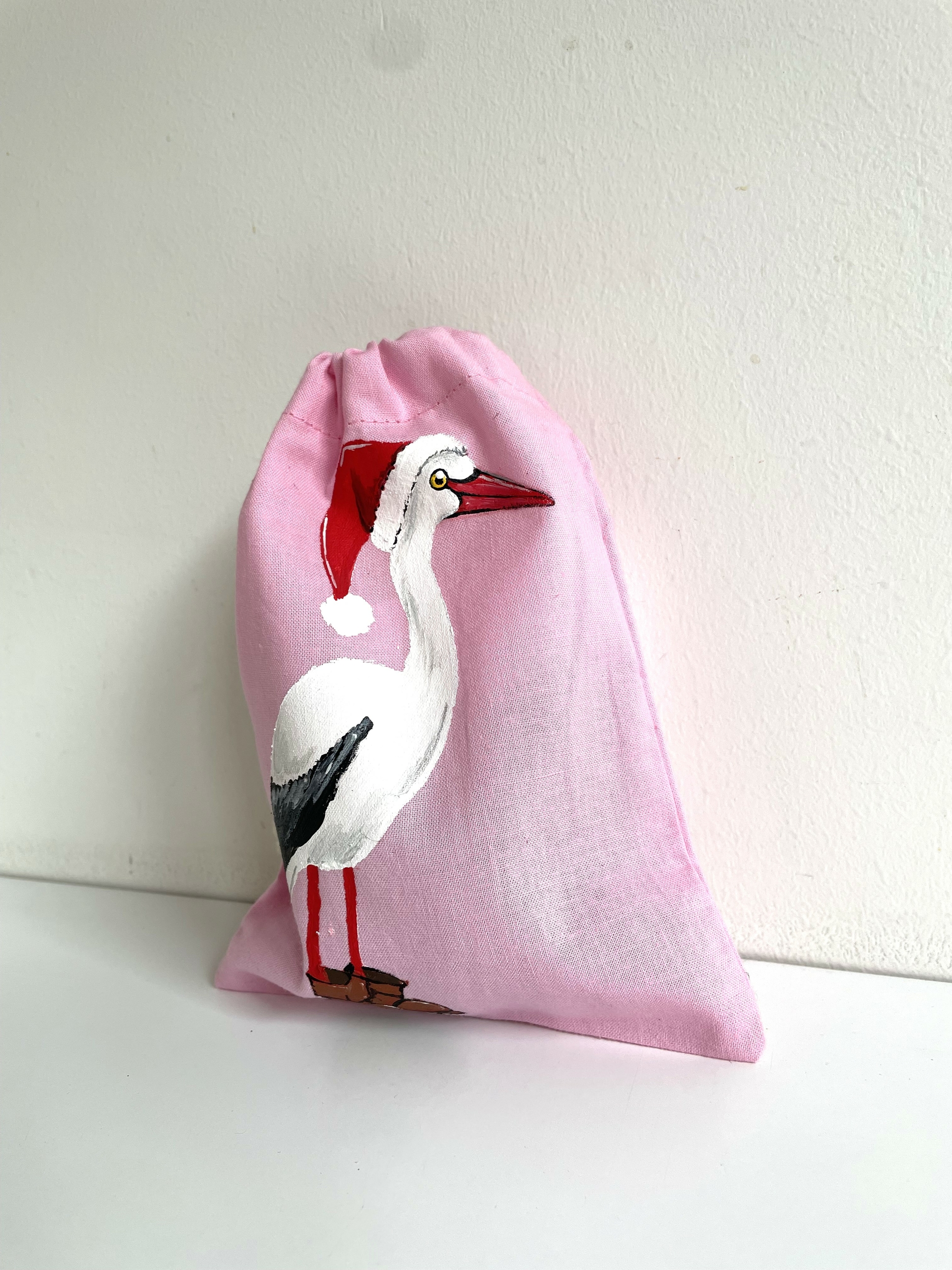 pochon rose avec cigogne de Noël peinte à la main  par Elles et No.